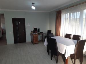 a dining room with a white table and chairs at Pensiunea agroturistica Casa Sirca in Boghiş