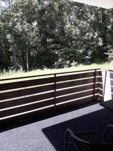 a wooden fence with a table and a chair at Ferienwohnung an der Klinge in Aalen