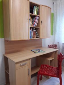 escritorio con silla roja y estante para libros en Ferienwohnung an der Klinge, en Aalen