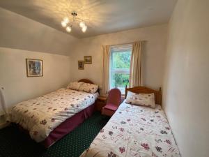 - une chambre avec 2 lits et une fenêtre dans l'établissement Masslink Guest House, à Horley