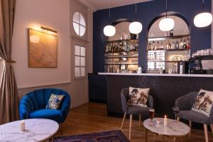 a bar with blue chairs and tables in a room at Hôtel Anne d'Anjou, The Originals Collection in Saumur