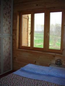 Habitación con ventana en una casa de madera en B&B Villa Letizia, en Agrate Conturbia