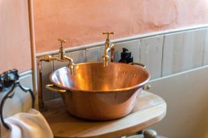 a copper tub with two faucets on top of a counter at Queen Mary's Chamber in Peebles