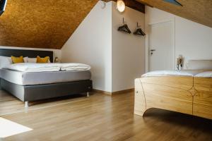 due letti in una stanza con pavimenti in legno di Sua Casa ad Amblève