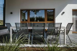 a glass table and chairs in front of a building at Sua Casa in Amblève