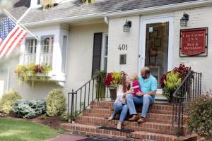 a family sitting on the steps of a house at Clay Corner Inn in Blacksburg