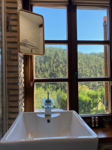 a bathroom sink with a mirror and a window at Urdaibai Etxea in Ea