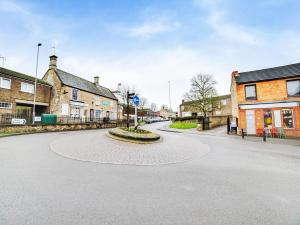 an empty street in a small town with buildings at Snooze Hotel in Corby