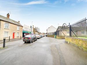 a parking lot with cars parked on a street at Snooze Hotel in Corby