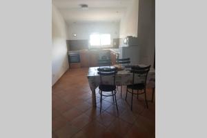 a kitchen with a table and chairs in a room at appartement tra mare e monti in Ghisonaccia