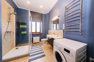 een blauwe badkamer met een wasmachine bij Kroņu nami in Liepāja