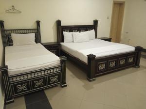 twee bedden naast elkaar in een kamer bij Hotel VIP Palace Lodge in Multan