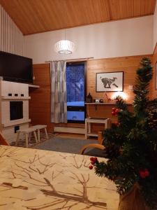 a living room with a christmas tree in a room at Kuosto ja Luppo in Äkäslompolo