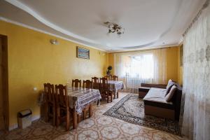 jadalnia ze stołem i krzesłami oraz żółtymi ścianami w obiekcie Захід сонця w Sławsku