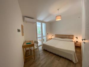 モンデッロにあるVilla DANAEのベッドルーム1室(ベッド1台、テーブル、窓付)