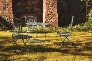 2 Stühle und ein Tisch im Gras in der Unterkunft Brennerei Haselberg in Wriezen