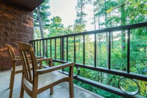 a balcony with two chairs and a view of trees at Chula Vista Resort, Trademark Collection by Wyndham in Wisconsin Dells