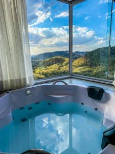 a bath tub with a view of the mountains at Pousada Colina das Andorinhas in Gonçalves