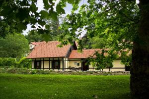 una casa con un tetto rosso su un campo verde di Hiška ob potoku a Dobrna