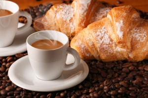 einen Tisch mit Tassen Kaffee und Brot in der Unterkunft Pensión Riosol in Sevilla