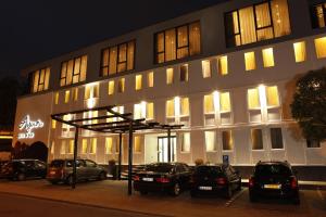 a building with cars parked in front of it at night at Centro Hotel Ayun in Cologne