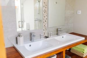 een badkamer met een witte wastafel en een spiegel bij Kroņu nami in Liepāja