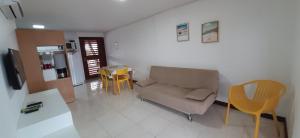 ein Wohnzimmer mit einem Sofa und einem Tisch in der Unterkunft Flat Praia dos Carneiros in Tamandaré
