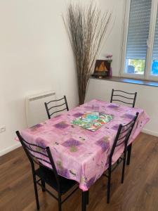 a dining room table with a pink table cloth on it at SPACIEUX T2 COSY SAINT-BRIEUC in Saint-Brieuc