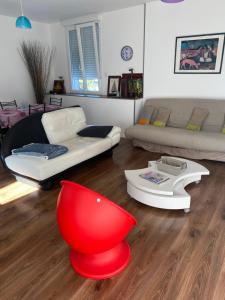 - un salon avec un canapé et un fauteuil rouge dans l'établissement SPACIEUX T2 COSY SAINT-BRIEUC, à Saint-Brieuc