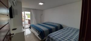 a small room with two beds and a window at Flat Praia dos Carneiros in Tamandaré +54 photos