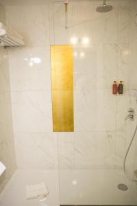 a shower with a glass door in a bathroom at Hôtel Le Versailles in Versailles