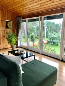 salon z kanapą i dużymi oknami w obiekcie Park Apartments w mieście Kulautuva