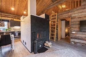 a large fireplace in a kitchen with wooden walls at UnelmaRepo in Ruka