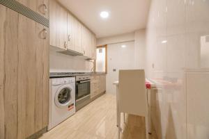 a kitchen with a washing machine and a washer at Apartamento Centro Santiago in Santiago de Compostela