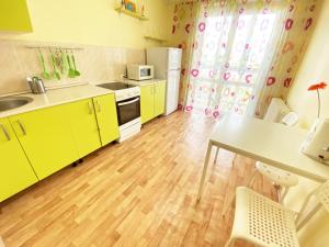ウファにあるApartment Revolyutsionnaya 68-50のウッドフロアのキッチン(黄色のキャビネット付)