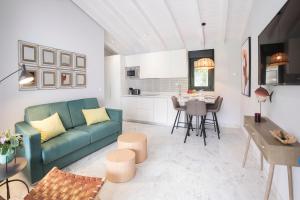 a living room with a green couch and a table at El Encanto Villas Boutique in Ribadesella