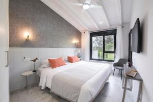 a bedroom with a large white bed and a window at El Encanto Villas Boutique in Ribadesella
