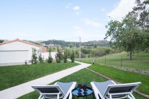 a patio with two lawn chairs and a table at El Encanto Villas Boutique in Ribadesella