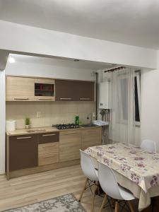 a kitchen with a table and a table and a table and chairs at 5 Residence Apartment in Cavnic