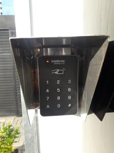 a black pay phone is attached to a building at Economy Apart in Natal