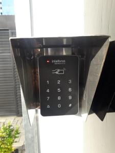 un teléfono público negro está conectado a un edificio en Economy Apart, en Natal