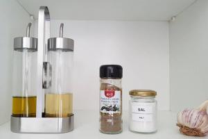 a counter with two bottles and a jar of spices at Pé n'Areia Guesthouse in Vila do Conde