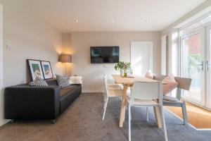 a living room with a black couch and a table at CONTRACTOR ACCOMMODATION SLEEPS 6 - 11 - MANCHESTER AIRPORT CITY in Manchester
