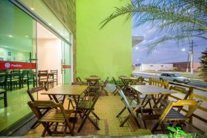 ein Restaurant mit Tischen und Stühlen und einer grünen Wand in der Unterkunft PUMMA BUDGET HOTEL in Canaã dos Carajás
