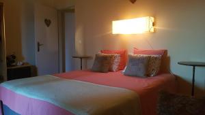 a bedroom with a bed with orange sheets and pillows at Quinta dos doze Sobreiros - Quarto Sol in Ferreira do Alentejo