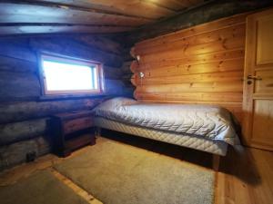 Nuorgam的住宿－Tenon Temppeli - Tilava huvila Lapissa，小木屋内的小卧室配有床