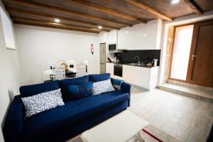 ein Wohnzimmer mit einem blauen Sofa und einer Küche in der Unterkunft Casa do Morgado in Mondim de Basto