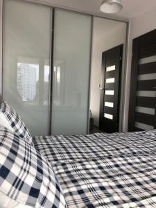 sypialnia z czarno-białym łóżkiem szachowym w obiekcie Apartament Ptasia w Zielonej Górze