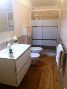 een badkamer met een toilet en een wastafel bij Le Orchidee in Bosa