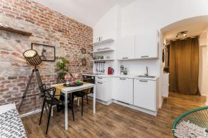 a kitchen with white cabinets and a brick wall at Apartmán u Stromovky nedaleko centra in Prague